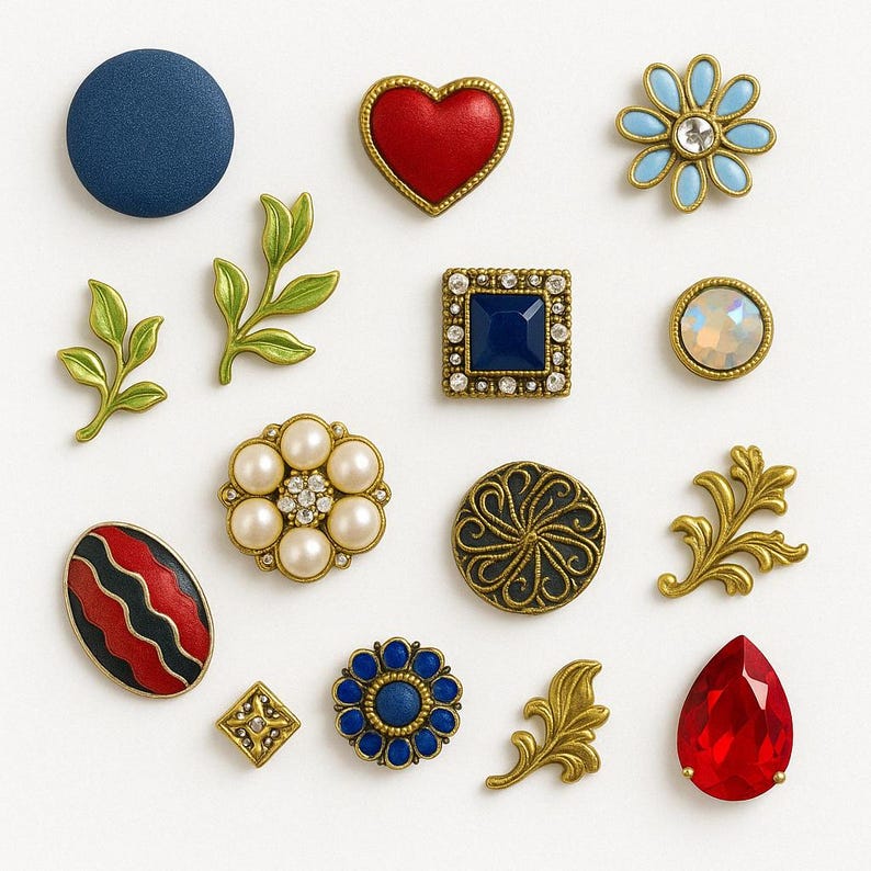 May include: Assortment of decorative buttons and embellishments in various shapes, colors, and materials.  Includes a red heart, a blue flower, a pearl button, a red and black striped button, and a gold leaf design.