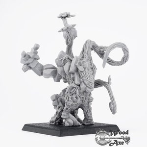 May include: A gray miniature fantasy figure of a creature with a rocky torso, vine-like limbs, and a head with a textured surface. The figure stands on a black square base. The Wood Axe logo is in the bottom right corner.