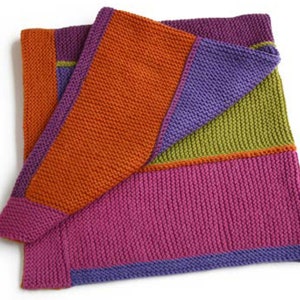Pu&ograve; includere: Una coperta di maglia con un motivo geometrico in tonalit&agrave; di arancione, viola, verde e rosa.