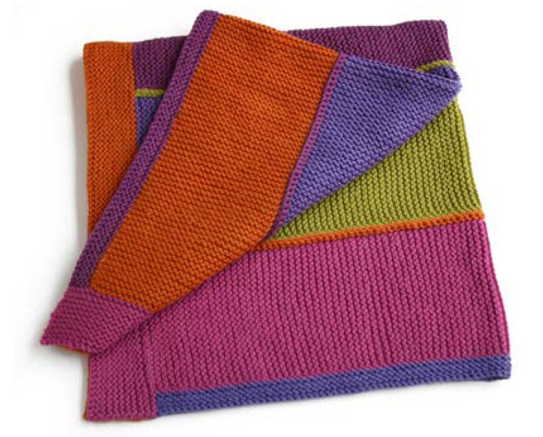 Pu&ograve; includere: Una coperta di maglia con un motivo geometrico in tonalit&agrave; di arancione, viola, verde e rosa.