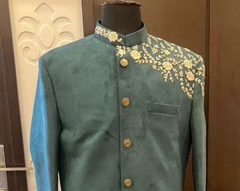 May include: A teal green long-sleeved kurta with gold button fastenings and intricate white and gold embroidery on the collar and sleeve cuffs.