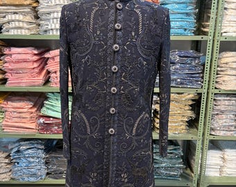 Puede incluir: Abrigo bordado azul marino con cuello mandarín y botones decorativos. El abrigo presenta intrincados patrones florales y de cachemira. El abrigo se exhibe en un maniquí con una etiqueta de talla 42.