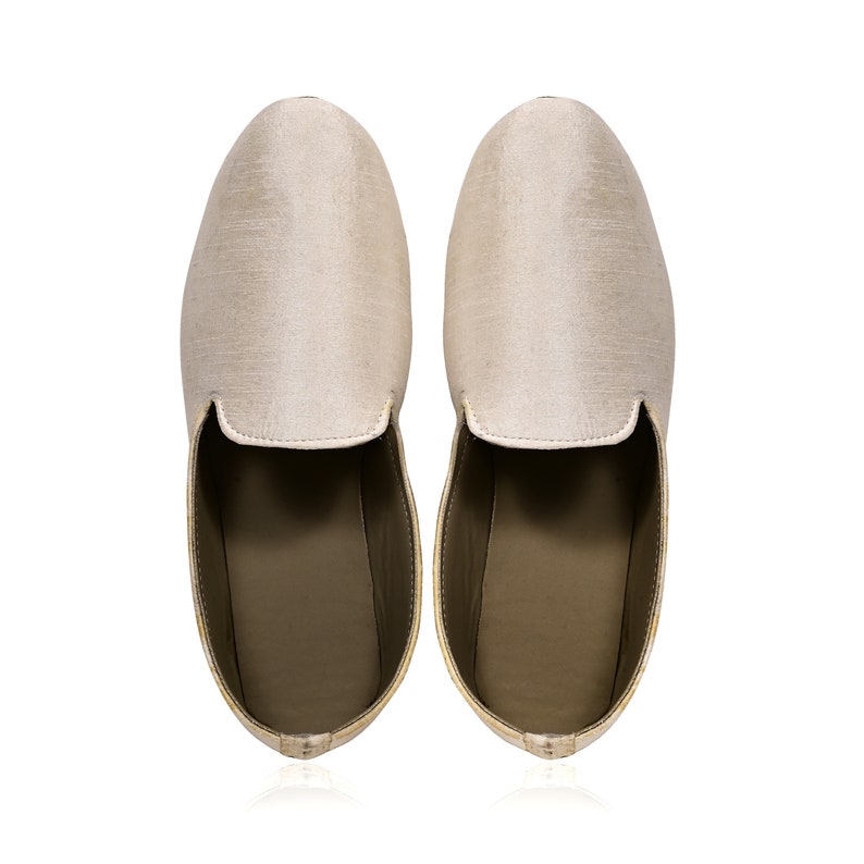 Peut inclure: Une paire de pantoufles en soie beige &agrave; bout pointu et &agrave; dos ferm&eacute;.