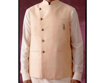 May include: A light beige sleeveless vest with a mandarin collar and five gold buttons. The vest has a small embroidered design on the right side.