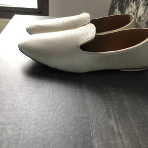 Peut inclure: Une paire de mocassins en cuir blanc &agrave; bout pointu.