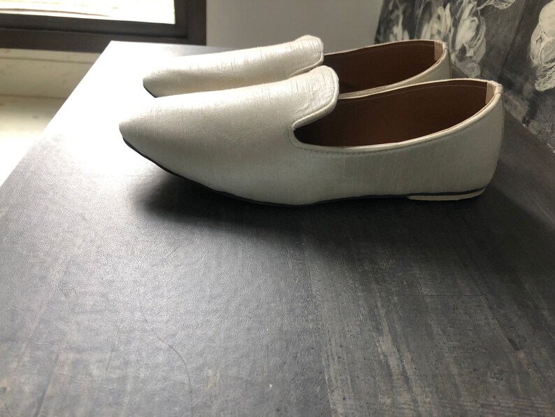 Peut inclure: Une paire de mocassins en cuir blanc &agrave; bout pointu.