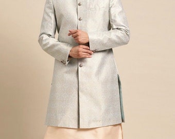 May include: A light gray long-sleeved kurta with a mandarin collar and button closure. The kurta has a subtle shimmer and a light blue lining on the side slits. The model is wearing the kurta with beige pants and a beige undershirt.