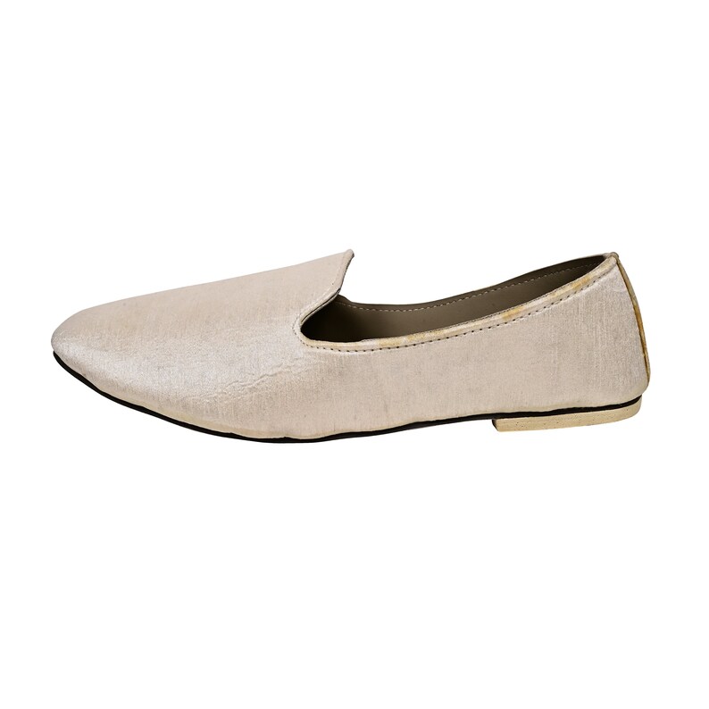 Peut inclure: Une paire de mocassins en velours beige clair avec une pointe pointue et une semelle plate.
