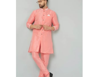 Puede incluir: Una kurta rosa de manga larga con cuello blanco y botones. La kurta se combina con pantalones rosas a juego. El modelo lleva zapatos negros.