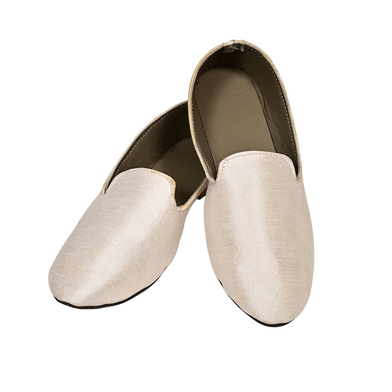 Peut inclure: Une paire de pantoufles en satin blanc cass&eacute; &agrave; bout pointu et &agrave; dos ferm&eacute;.
