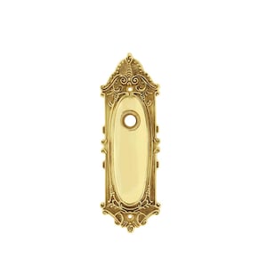 May include: Ornate brass door plate with an oval center and decorative scrollwork. The plate features a keyhole and is finished in a polished gold color. A classic hardware piece.