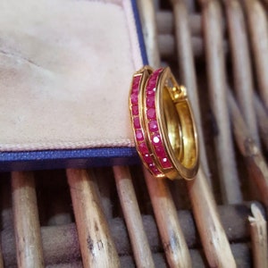 Op de afbeelding: Gouden creolen met twee rijen rode robijnstenen.