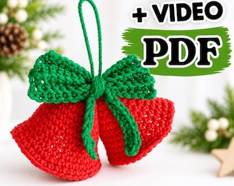 May include: A pair of red crocheted bells joined by a green crocheted bow and a hanging loop. The text + VIDEO PDF is displayed in black letters over a green brushstroke graphic above the bells.