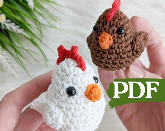 May include: Two crocheted chicken toys. One is white with a red comb and the other is brown with a red comb. Both have black eyes and orange beaks. The word "PDF" is written in green on a white background.
