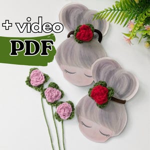 May include: The image features a green banner with the text "+ video PDF". There are three illustrated paper dolls with gray hair and red crocheted rose hair accessories. Also, there are three pink crocheted roses with green leaves.