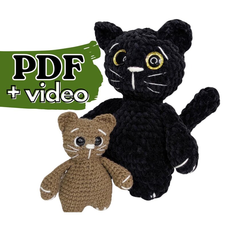 May include: Two crocheted cat plushies, one larger black cat and one smaller brown cat, both featuring white embroidered whiskers, white paw details, and large plastic eyes. A green graphic overlay displays the text PDF + video.