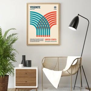 May include: Framed poster featuring a retro design for Yosemite National Park. The artwork includes the park's name, coordinates, and a stylized graphic in teal and red. The poster is displayed in a light wood frame.