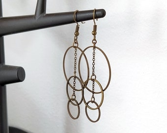 May include: A pair of gold-toned earrings with a chain and multiple interlocking circles.