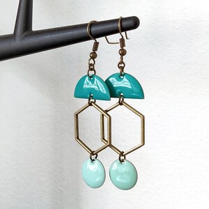 May include: Teal and light green geometric earrings with a hexagonal design and a half-circle top.