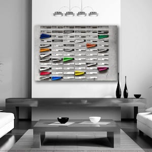 Peut inclure: Une photographie en noir et blanc d'un mur avec une grille de boîtes aux lettres. Chaque boîte aux lettres a un petit avion en papier coloré collé dessus.