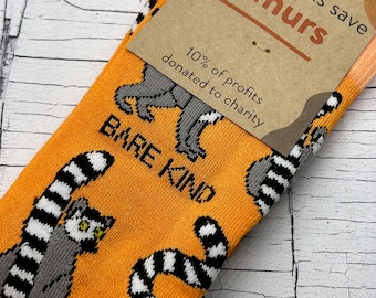 May include: Orange socks with a black and white striped lemur design. The socks have the text "BARE KIND" and "these socks save lemurs" on the tag. 10% of profits are donated to charity.