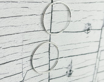 May include: A pair of silver hoop earrings. The earrings are simple and elegant, and they would be a great addition to any jewelry collection.