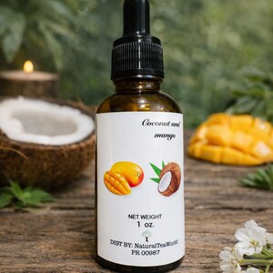 May include: A brown glass bottle with a black dropper, labeled "Coconut and mango." The label features illustrations of a mango and coconut. The bottle is 1 oz. and is on a wooden surface.