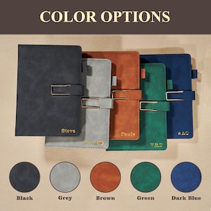 May include: A selection of personalized notebooks in black, grey, brown, green, and dark blue. Each notebook features a gold-colored clasp and is embossed with a name or initials. The text "COLOR OPTIONS" is at the top, with color swatches below.