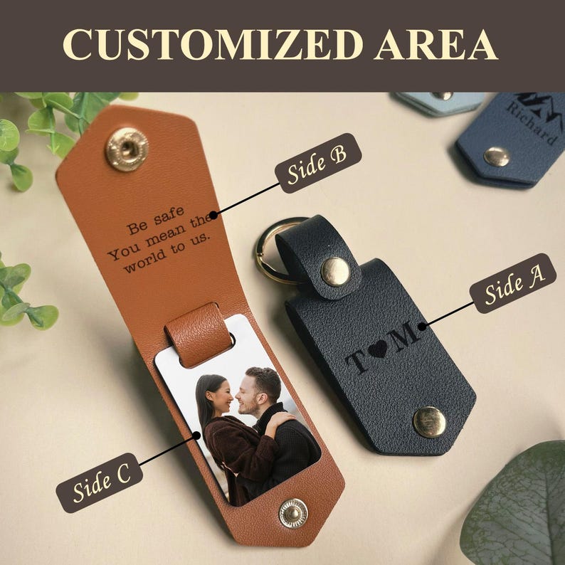 May include: A brown leather keychain with a photo insert and a personalized message. The message reads "Be safe You mean the world to us." The keychain also has a black leather side with the text "T&hearts;M".