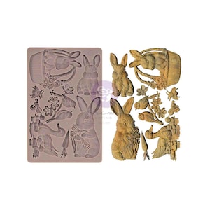 May include: A silicone mould and decorative elements featuring Easter-themed designs. The mould includes bunny rabbits, flowers, birds, and a basket. The decorative elements include detailed bunny rabbits, birds, and a basket with flowers.