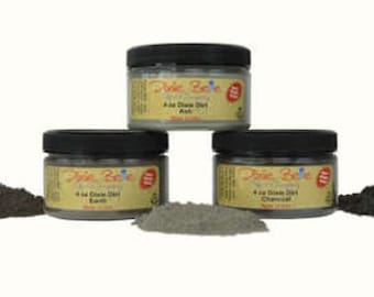 May include: Three jars of 4 oz. Clean Dirt, a natural clay-based paint, in the colors Charcoal, Earth, and Ant. Each jar has a black lid and a label with the company name "Dixie Belle" and the product name.