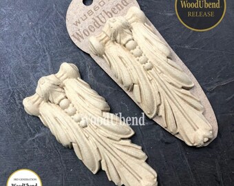 May include: Two beige wood appliques with a leaf and berry design. One applique is attached to a tag with the text "WoodUbend" and "WU86076". The tag also has a hole for hanging. The appliques are labeled "NEW RELEASE" and "3RD GENERATION WoodUbend IMPROVED DESIGN".