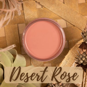 May include: A small round container of blush makeup in a light peach colour. The container is labelled "Desert Rose".