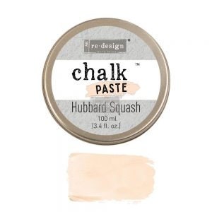 May include: A round tin of Redesign Chalk Paste in the color Hubbard Squash. The tin is silver with black lettering and a pink accent. The paste is a light peach color.