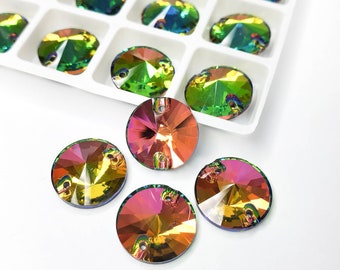 May include: Iridescent, round crystal rhinestones in a white tray and scattered on a white surface. The crystals have a flat back with two holes for sewing or gluing. The crystals reflect colors of pink, orange, yellow, and green.