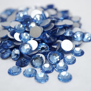 May include: A pile of light blue rhinestones with a flat back, perfect for crafting and decorating.