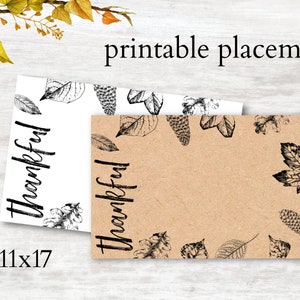 Op de afbeelding: Printbare placemat met een bruine kraftpapier achtergrond en zwarte bladeren ontwerpen. De tekst "Thankful" is in zwart geschreven op zowel de witte als de bruine placemats. De placemats zijn 11x17 inch.