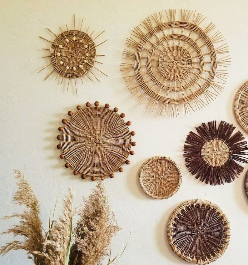 May include: A collection of six woven wall decor pieces in various shapes and sizes. The pieces are made of natural materials and have a rustic, bohemian aesthetic.