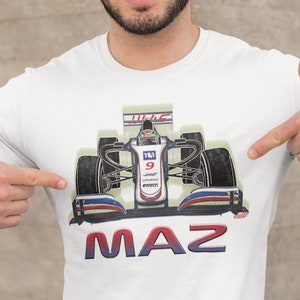 Peut inclure: T-shirt blanc avec un imprimé d'un pilote de course dans une voiture de course blanche et bleue avec le numéro 9 sur le côté. Le texte "MAZ" est imprimé sous la voiture.