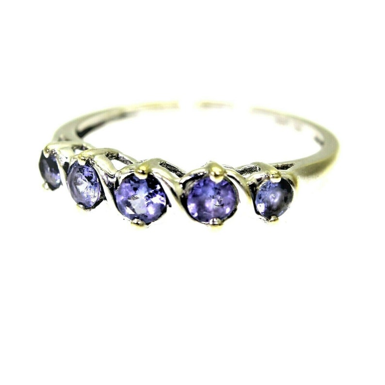 May include: A silver ring with five purple gemstones set in a twisted band.