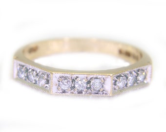 Op de afbeelding: Een gouden ring met een rij kleine diamanten die in een wit metalen frame zijn gezet.