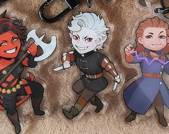 May include: Set of seven clear acrylic keychains featuring cartoon characters. The characters are a white dog with stars on its eyes, a girl with long black hair and a white dress, a girl with red hair and a brown dress, a boy with red hair and a brown shirt, a boy with white hair and a black shirt, a girl with brown hair and a purple shirt, and a girl with red hair and a red shirt.