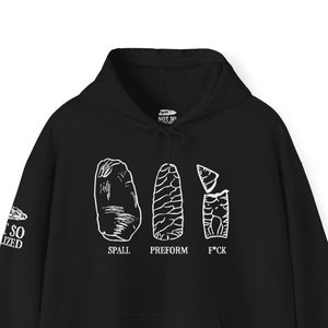May include: Black hoodie with a white graphic of three stages of stone tool making. The graphic shows a spall, a preform, and a finished tool. The text below the graphic reads "SPALL, PREFORM, F*CK".