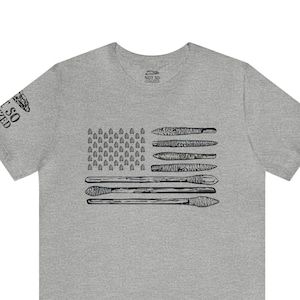Puede incluir: Una camiseta gris jaspeada con un gráfico en blanco y negro de una bandera estadounidense hecha de herramientas. El texto "Not So Civilized" está impreso en la etiqueta.