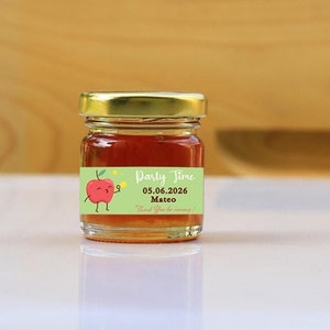 May include: A small glass jar of honey with a green and red label that says "Party Time 03.06.2026 Mateo".