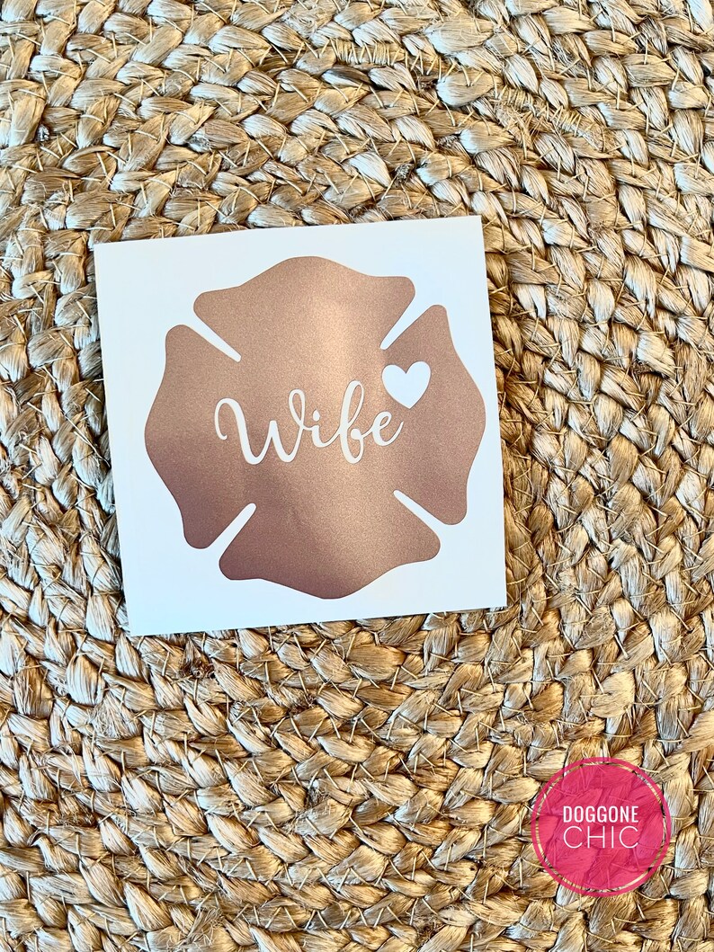 May include: A rose gold firefighter's helmet decal with the word "Wife" and a white heart.