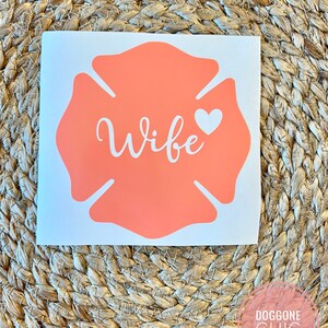 May include: A coral-coloured firefighter's helmet decal with the word "Wife" and a small white heart.