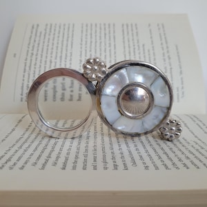 Lupa de mano plegable de estilo victoriano antiguo de metal plateado y nácar, con hermoso detalle de flor.