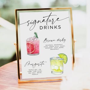 May include: A gold-framed sign with the words "signature DRINKS" in elegant script. The sign features watercolor illustrations of two cocktails: a pink "Brown Derby" and a yellow "Margarita", with their ingredients listed below.