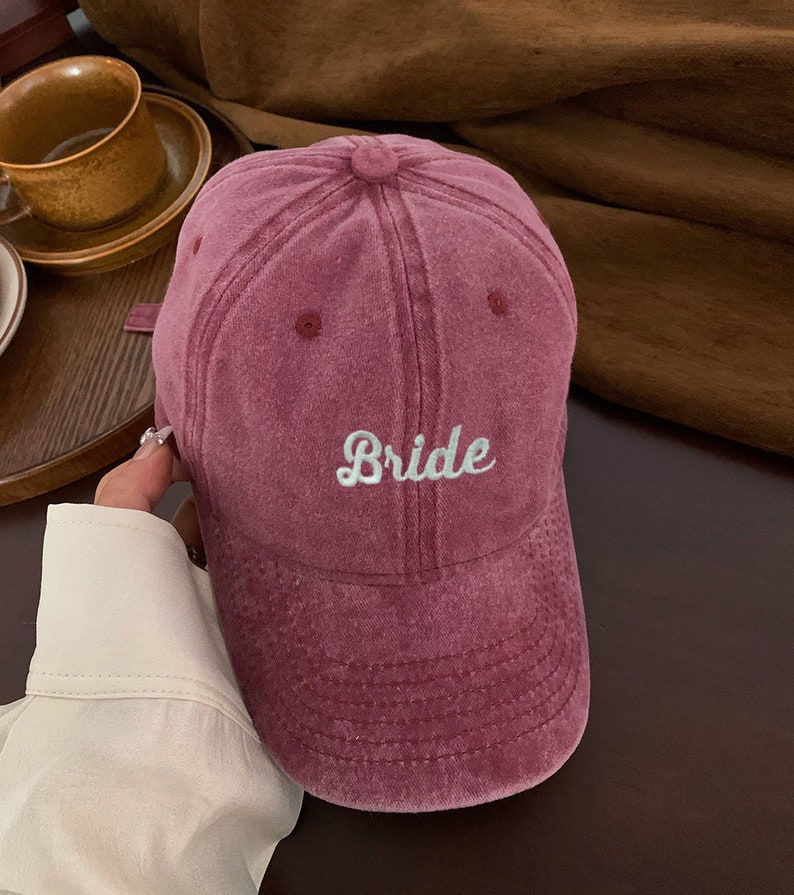 Puede incluir: Una gorra de b&eacute;isbol de color burdeos con la palabra "Bride" bordada en blanco en la parte delantera.